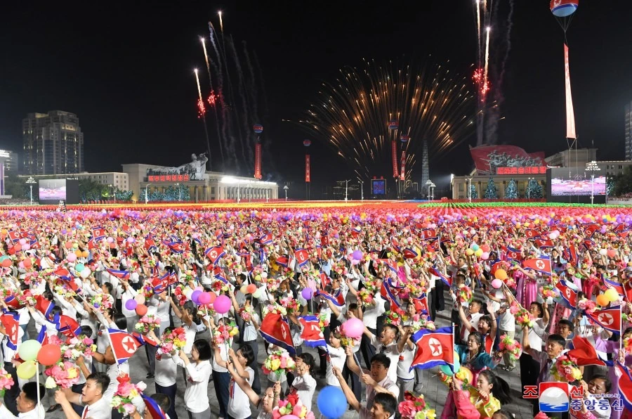 Người dân cầm hoa và quốc kỳ Triều Tiên dự lễ duyệt binh bán quân sự hôm 8-9 nhân kỷ niệm 75 năm quốc khánh. Ảnh: KCNA