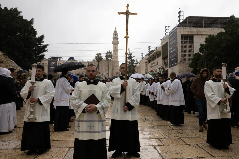 Các tu sĩ Công giáo làm lễ gần Nhà thờ Giáng sinh ở TP Bethlehem (Bờ Tây) hôm 24-12. Ảnh: THE WASHINGTON POST Một mùa Giáng sinh buồn trên TP cổ Bethlehem vì chiến sự ở Gaza