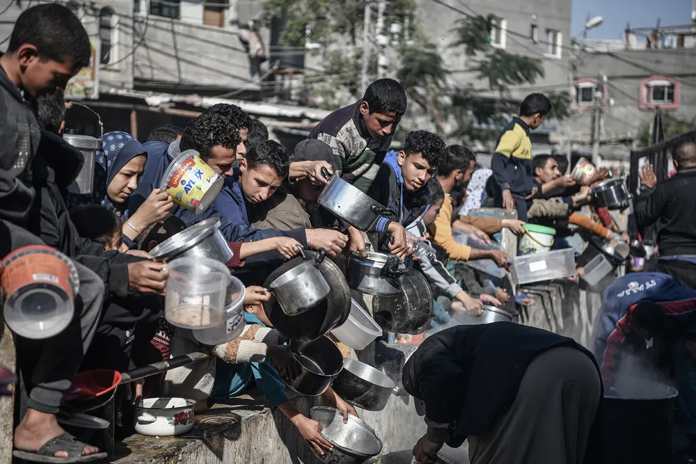 Người dân Gaza nhận thực phẩm và hàng cứu trợ nhân đạo hôm 19-12. Ảnh: ANADOLU AGENCY anh-5-1-4925.jpg