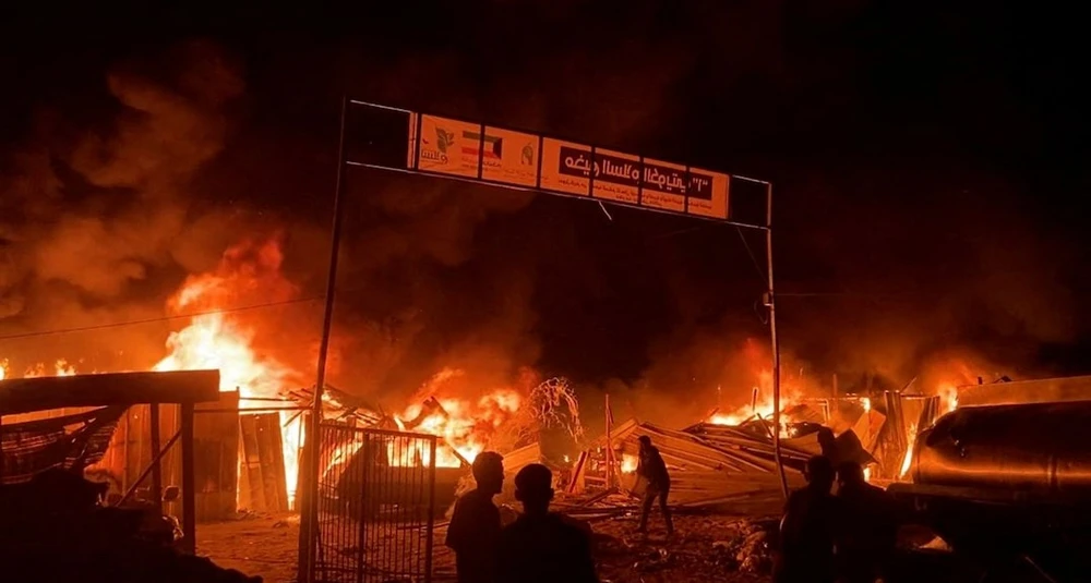 Lửa cháy dữ dội sau cuộc không kích của Israel vào trại tị nạn ở TP Rafah (cực nam Gaza) khiến 45 người chết hôm 26-5. Ảnh: REUTERS Israel không kích trại tị nạn.jpeg