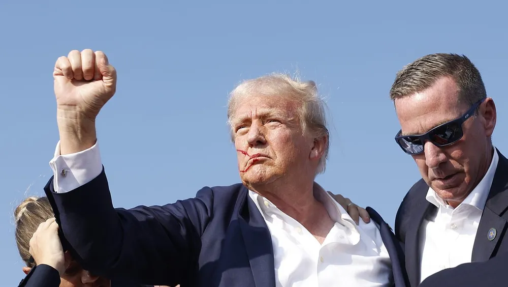 Cựu Tổng thống Donald Trump được Mật vụ Mỹ hỗ trợ sau khi bị bắn tại vận động tranh cử ở bang Pennsylvania ngày 13-7. Ảnh: REUTERS ông trump bị bắn.jpg