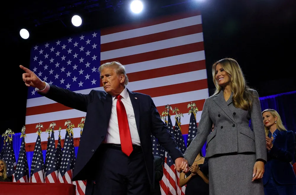 Tổng thống đắc cử Donald Trump nắm tay phu nhân Melania Trump tại sự kiện ở West Palm Beach, bang Florida (Mỹ) hôm 6-11. Ảnh: REUTERS tổng thống đắc cử Trump 2.jpg