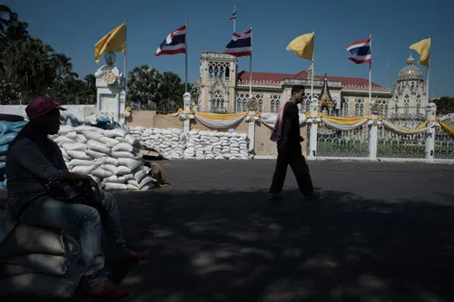 [Caption]Thai anti-government protesters walk and sit outside the Government house in Bangkok on January 12, 2014.