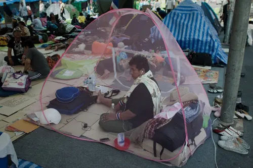 [Caption]Thai anti-government protesters relax on a street outside the Government house in Bangkok on January 12, 2014.