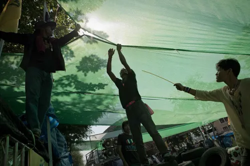 [Caption]Thai anti-government protesters set up a spot with shade on a street outside the Government house in Bangkok on January 12, 2014.