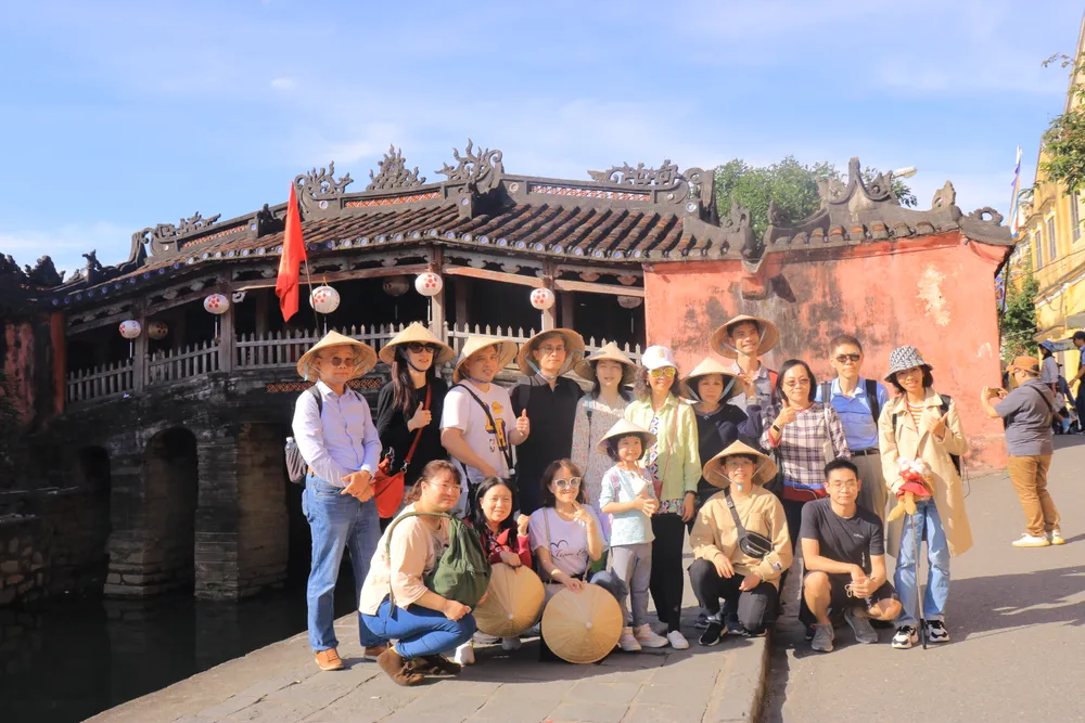 Một nhóm du khách chụp ảnh kỷ niệm bên Chùa Cầu.