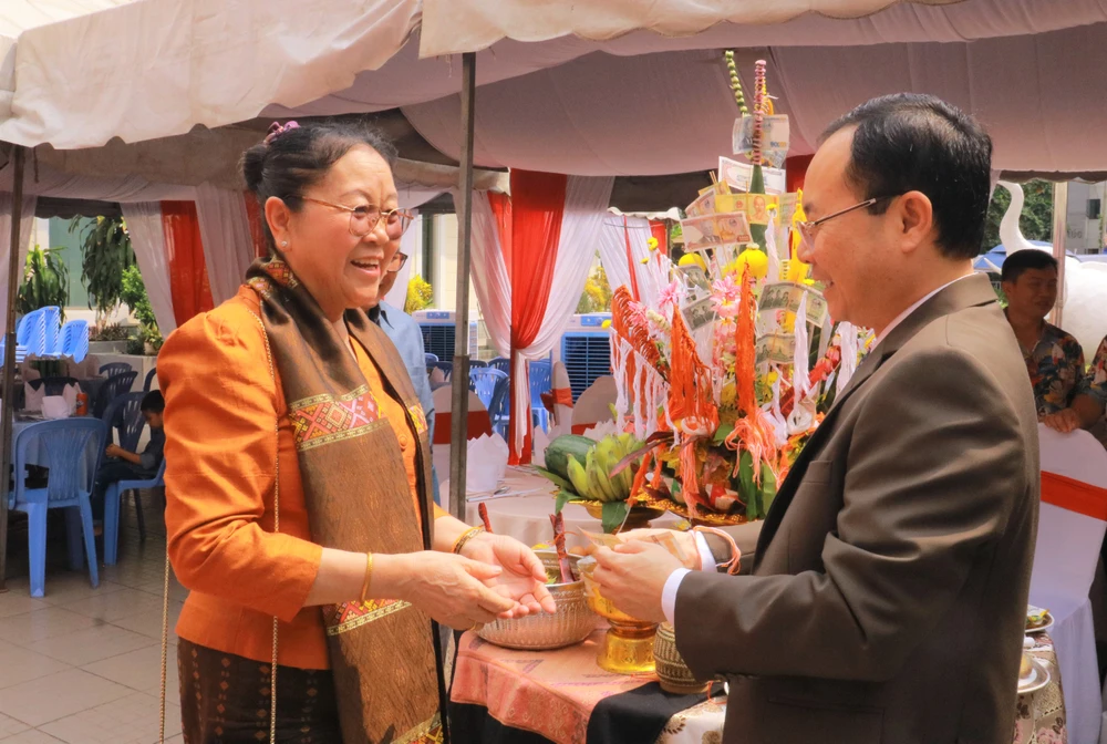 Tổng Lãnh sự Lào Phimpha Keomixay buộc vòng chỉ cho Phó Bí thư Nguyễn Văn Hiếu với ý nghĩa cầu chúc hạnh phúc và sức khỏe. Ảnh: VÕ THƠ