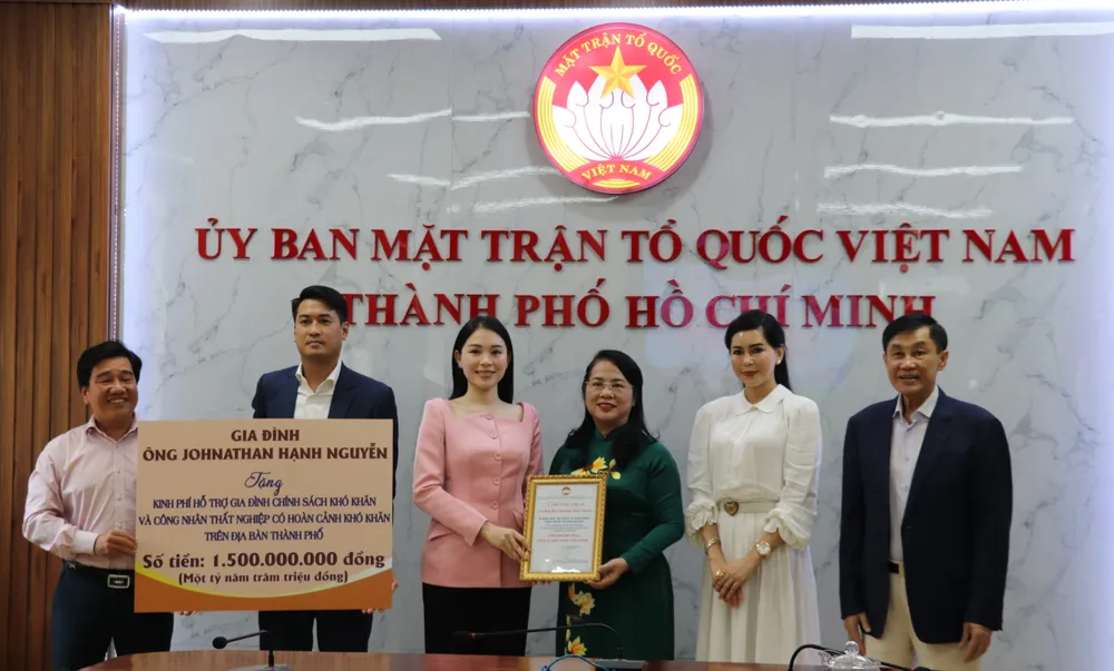 Chủ tịch Ủy ban MTTQ Việt Nam TP Trần Kim Yến nhận kinh phí hỗ trợ từ gia đình ông Johnathan Hạnh Nguyễn. Ảnh: AH