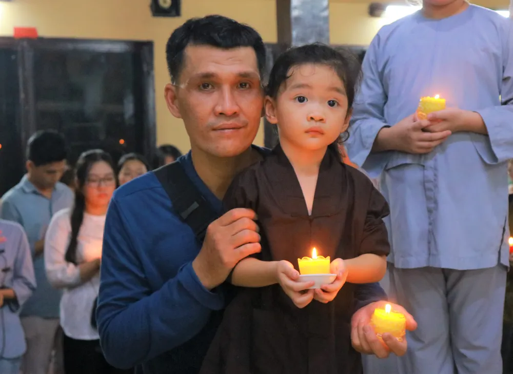 Những em bé theo cha mẹ đi chùa thắp nến tri ân để hun đúc tình cảm, lòng biết ơn đối với công lao dưỡng dục của đấng sinh thành. Ảnh: VÕ THƠ