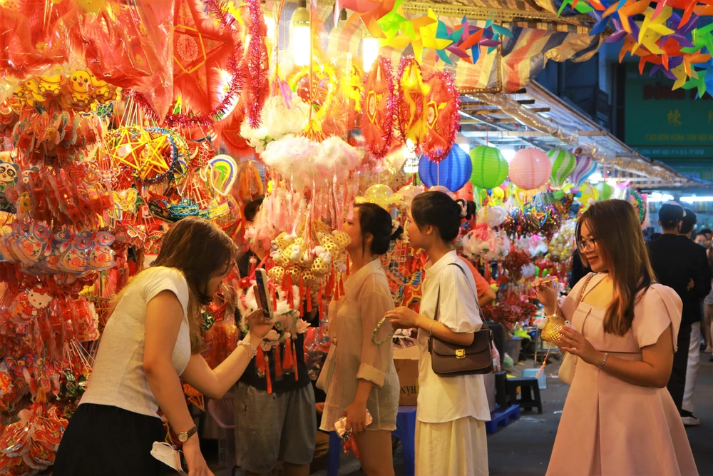 Bạn Tâm Nguyên (ngụ quận Bình Thạnh) cùng bạn thân đến chụp ảnh, lưu giữ khoảng khắc nhân dịp rằm tháng 8. "Thời điểm này là thích hợp nhất để lên đồ chụp ảnh vì vài hôm nữa chắc chắn sẽ đông hơn. Đến đây rất nhiều sản phẩm lạ mắt, đa dạng nên ngoài chụp ảnh mình còn mua một ít để đem về trang trí cho gia đình" Nguyên chia sẻ.