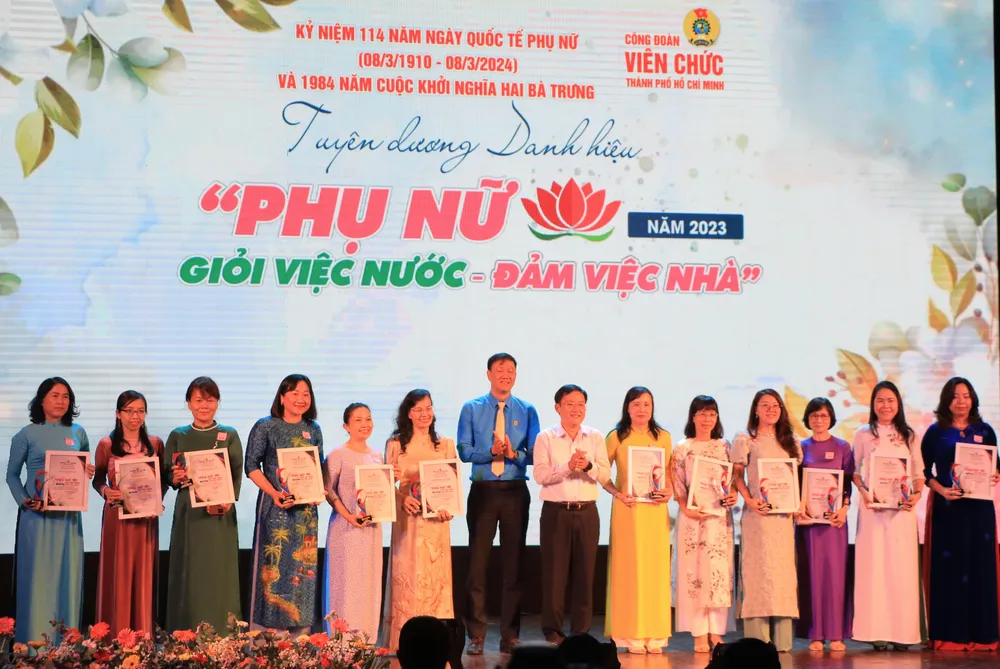 Chủ tịch Công đoàn Viên chức TP Lương Tuấn Anh và Phó Chủ tịch LĐLĐ TP Phùng Thái Quang trao tuyên dương cho các gương phụ nữ “Giỏi việc nước, đảm việc nhà”. Ảnh: VT duyên dáng áo dài