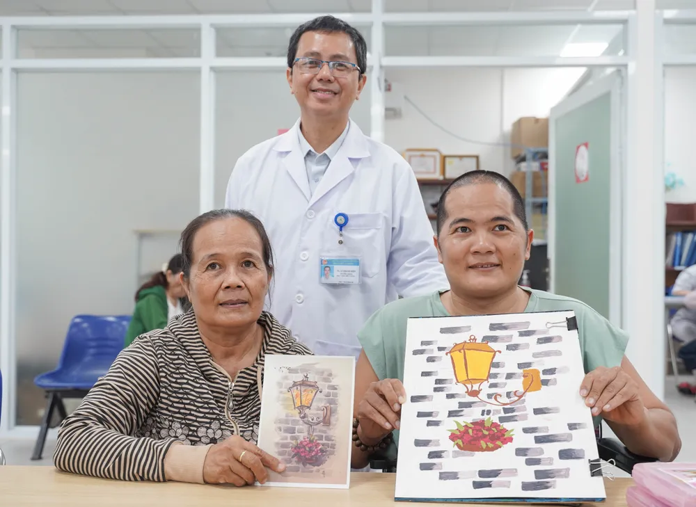 Tiến sĩ Lê Khánh Điền chụp ảnh kỷ niệm cùng mẹ con bà Lê Thị Nga (56 tuổi) đã tham gia lớp vẽ 5 tháng tại bệnh viện. lop-ve-dac-biet (19).jpg