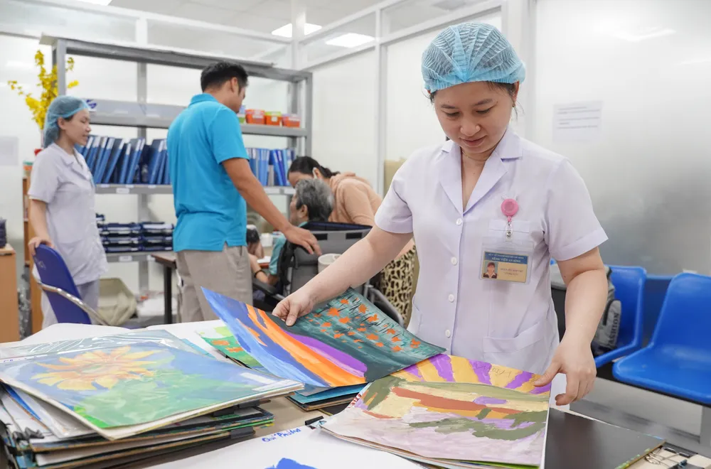 Sau giờ vẽ, các y tá cẩn thận sắp xếp lại tranh của bệnh nhân. Các bức tranh nổi bật sẽ được treo ở hành lang của khoa Phục hồi chức năng. Đến cuối năm, khoa sẽ tổ chức triển lãm những tranh vẽ này tại bệnh viện. lop-ve-dac-biet (6).jpg
