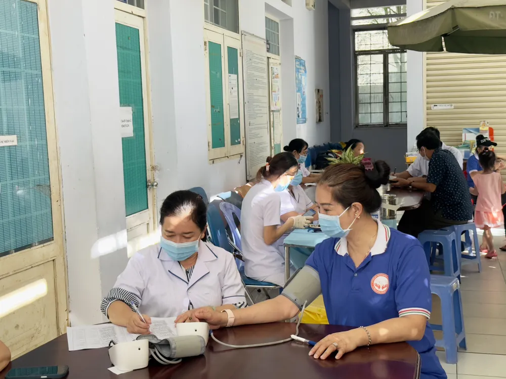 Người dân được các nhân viên y tế đo huyết áp. Ảnh: TRẦN MINH