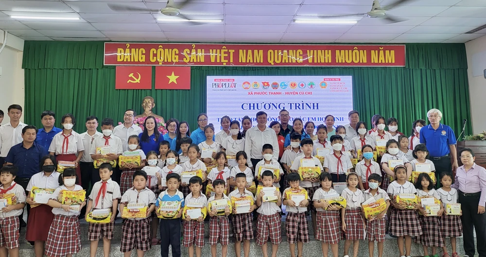 Công đoàn báo Pháp Luật TP.HCM phối hợp UBND xã Phước Thạnh, huyện Củ Chi, TP. HCM trao tặng 49 phần quà cho học sinh khó khăn. Ảnh: PHI LONG