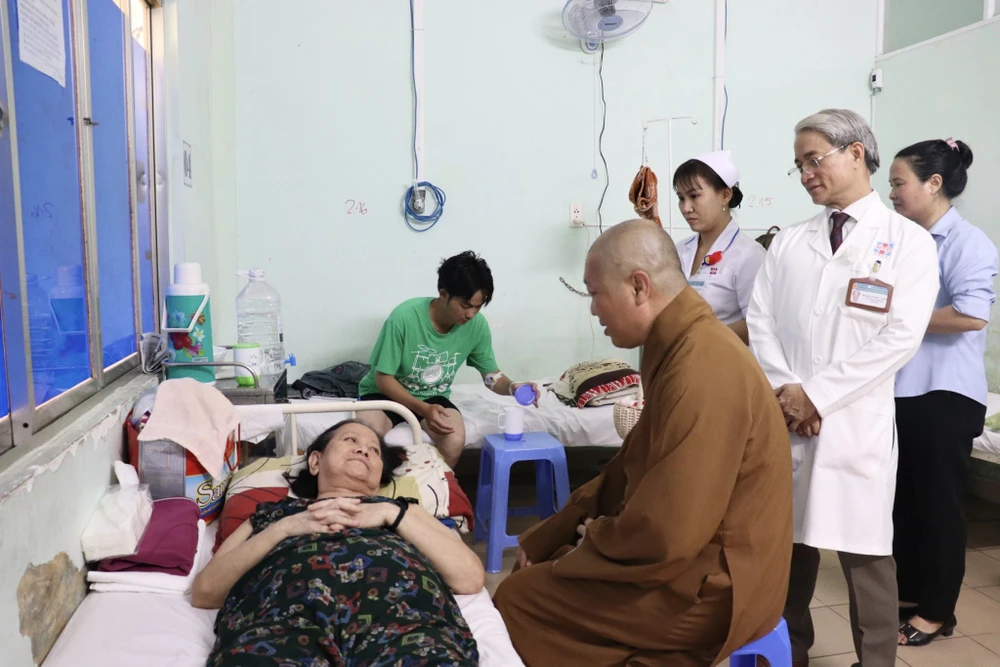 BS Võ Đức Chiến, Giám đốc bệnh viện Nguyễn Tri Phương cùng Thượng Tọa Thích Thiện Thuận đến thăm hỏi và cài bông hồng cho các bệnh nhân. Ảnh: TRẦN MINH