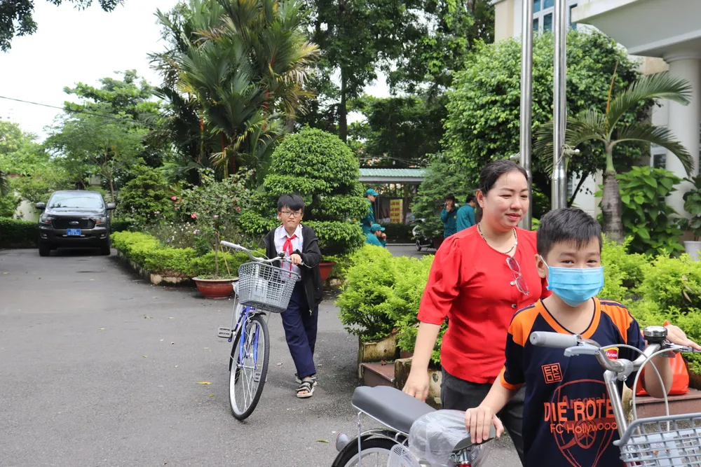Các em học sinh vui mừng khi nhận được xe đạp mới. Ảnh: TRẦN MINH