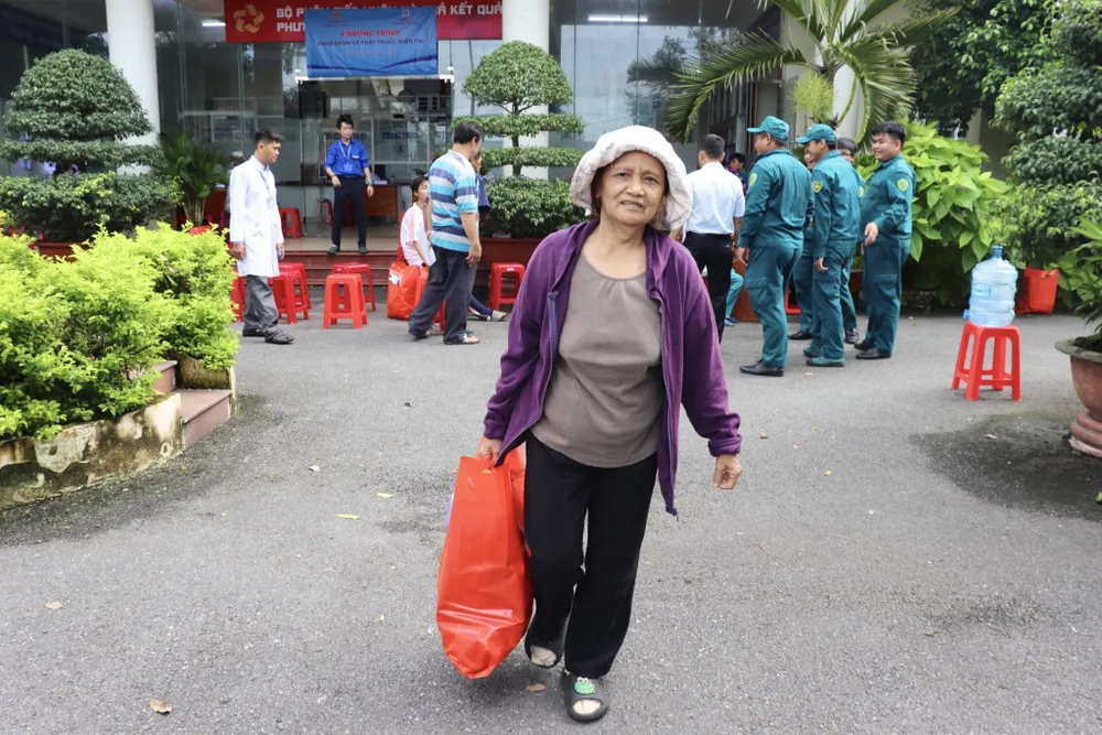 Bà Nguyễn Thị Mỹ Dung vui mừng cầm trên tay phần quà sau khi được các y bác sĩ BV Nhân dân Gia Định thăm khám, phát thuốc miễn phí. Ảnh: TRẦN MINH