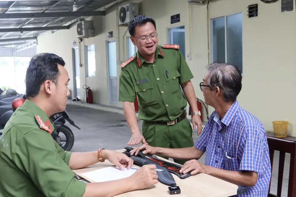 Đại úy Trịnh Văn Thanh giải thích cho người dân hiểu rõ về hành vi tàng trữ vũ khí là vi phạm pháp luật. Ảnh: TRẦN MINH giao nộp vũ khí 3.jpg