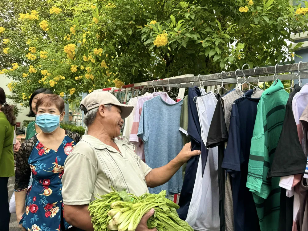 Ngoài phiên chợ người dân còn được lựa những bộ quần áo mới. Ảnh: TRẦN MINH z5062055278328_30e647f1cd4cbf195ead93f7064d0623 (1).jpg