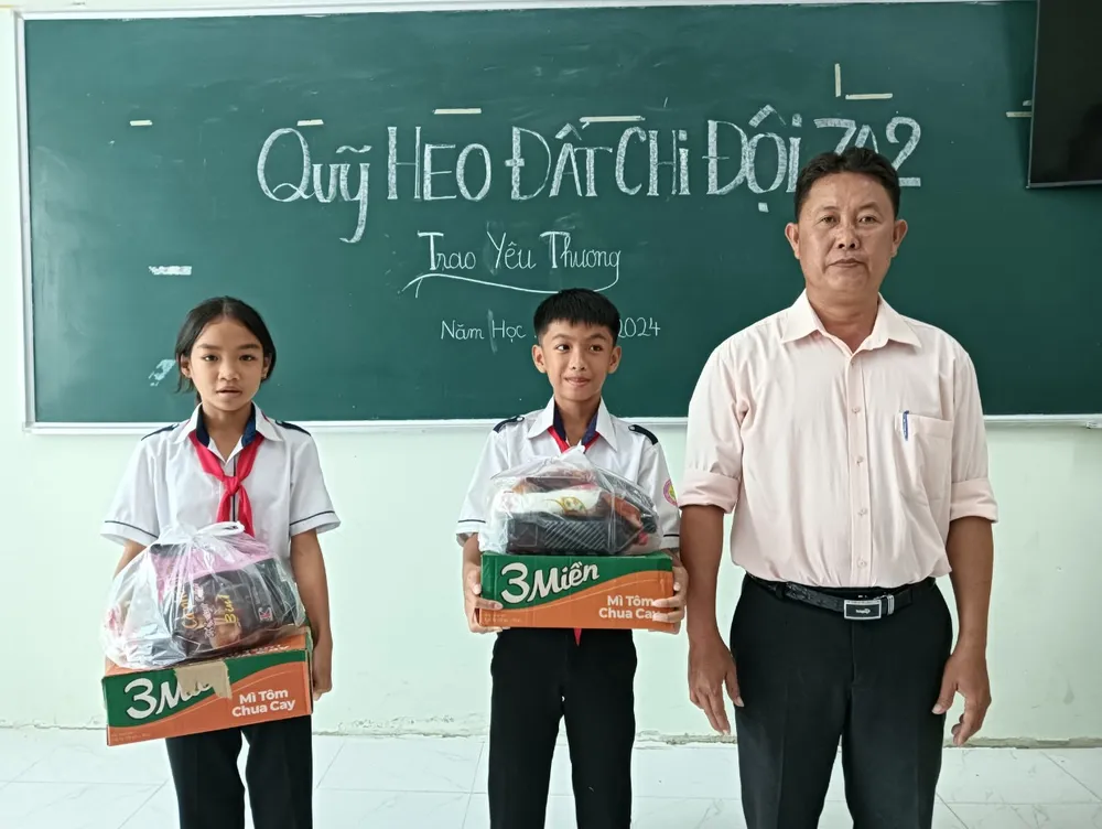 Ngọc Thi (phải) và Gia Kiệt nhận quà Tết từ việc "nuôi" heo đất của bạn cùng lớp. Ảnh: HT IMG_3503.jpeg