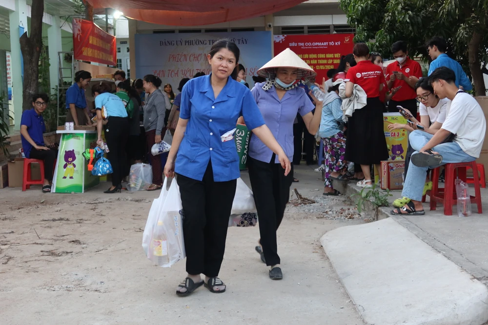 Người dân vui mừng ra về với những phần quà, nhu yếu phẩm. Ảnh: TRẦN MINH IMG_8435.JPG
