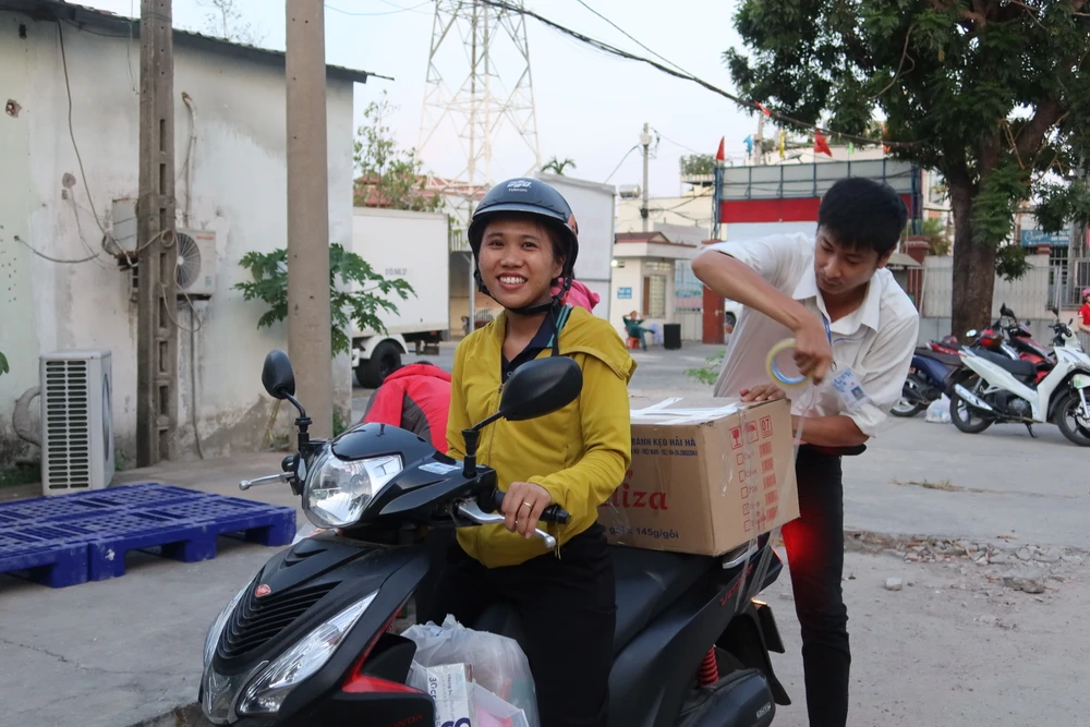 Chị Bắc vui vẻ mang về các nhu yếu phẩm mua tại phiên chợ nghĩa tình. Ảnh: TRẦN MINH IMG_8454.JPG