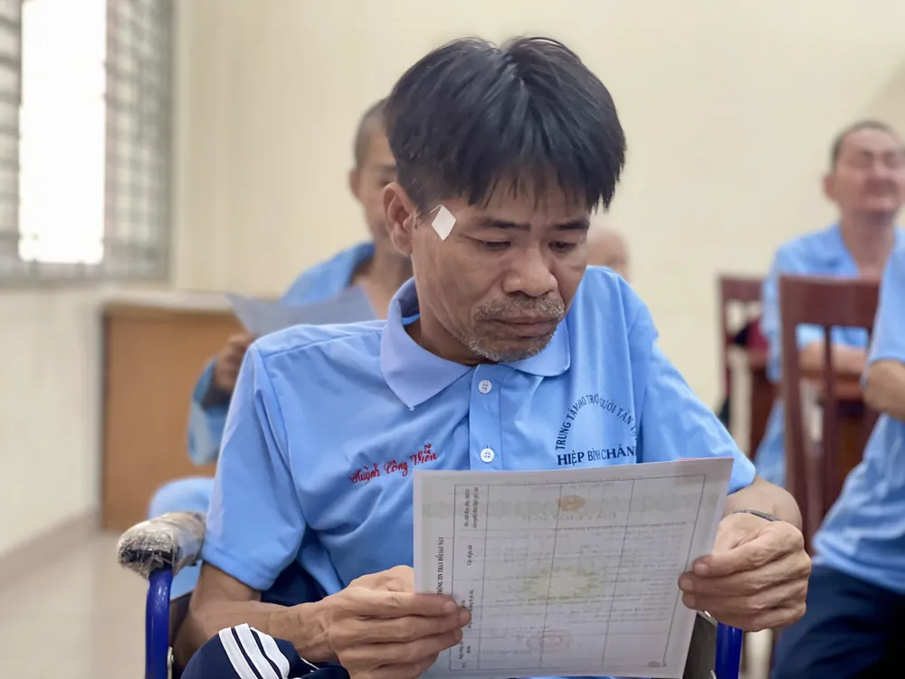 Ông Viễn hạnh phúc khi được cầm tờ giấy khai sinh của mình. Ảnh: HUỲNH THƠ giay-khai-sinh-1.jpg
