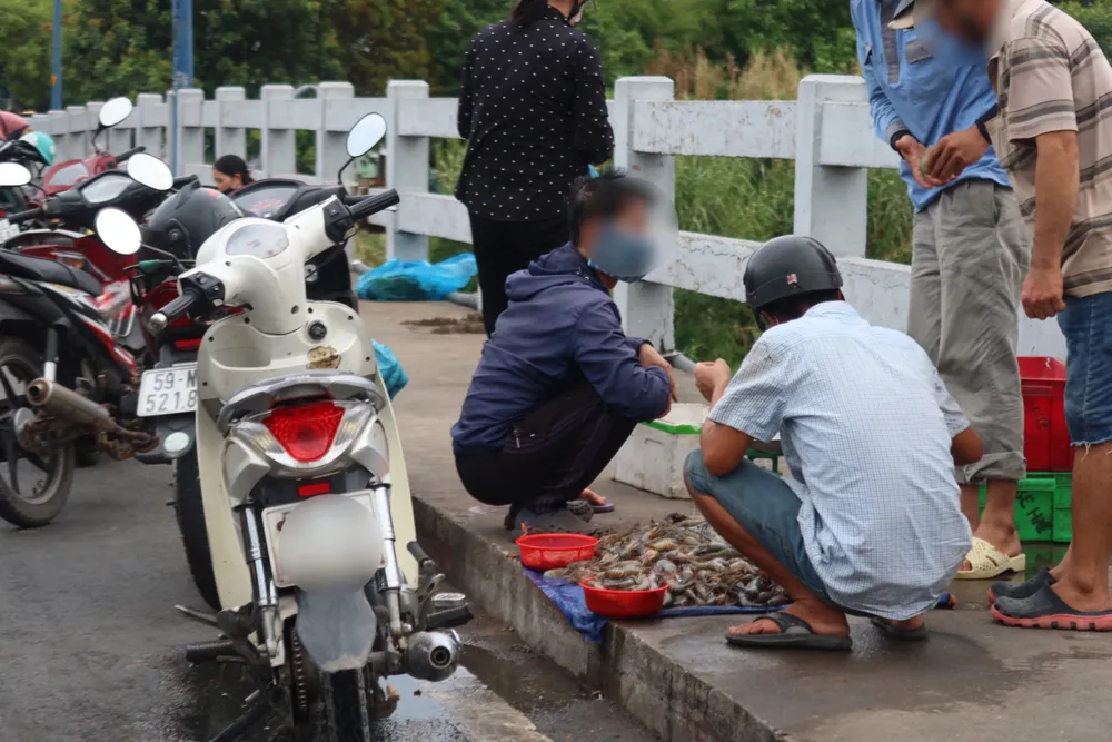 Nước thải sau khi làm tôm, cá,...ra đường khiến cả khu vực thường xuyên bốc mùi hôi tanh. Ảnh: TRẦN MINH buôn bán hàng hóa trên cầu A