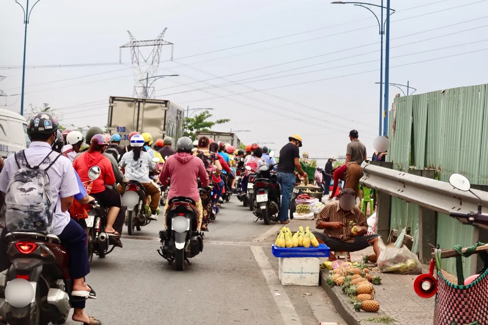 Tại cầu A, quận Bình Tân, vào tầm chiều lượng xe lưu thông qua khu vực này khá đông kèm theo việc lấn chiếm mua bán trên cầu, tiềm ẩn nguy cơ mất an toàn giao thông rất cao. Ảnh: TRẦN MINH tụ tập buôn bán trên cầu