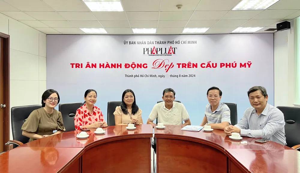 Anh Mai Lê Duy Quang chụp hình lưu niệm cùng nhà tài trợ và ban tổ chức buổi trao học bổng. Ảnh: TRẦN MINH anh Mai Lê Duy Quang