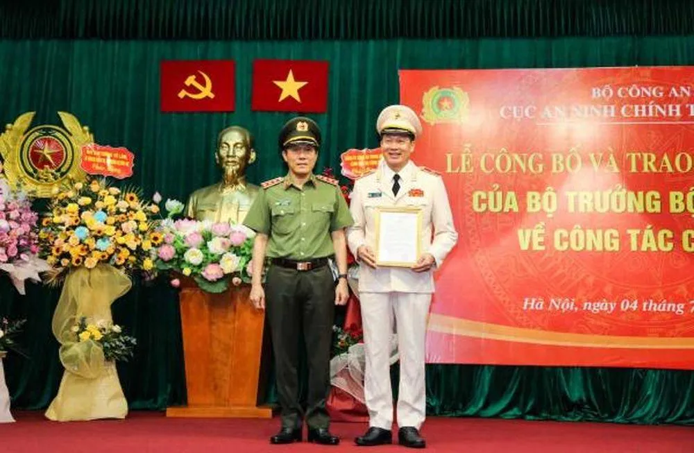 Thứ trưởng Lương Tam Quang trao quyết định, tặng hoa chúc mừng Thiếu tướng Vũ Hồng Văn, tân Cục trưởng Cục An ninh chính trị nội bộ. Ảnh: CAND.