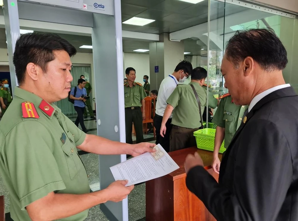 Cơ quan công an kiểm tra giấy tờ người tham dự phiên tòa. Ảnh: VH.