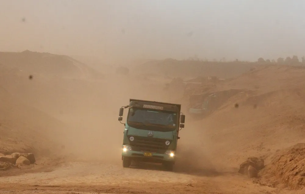 Những chiếc xe ben chở đất đi trong công trình bụi bay dầy đặc khiến một số tài xế phải bật đèn sương mù để cảnh báo.