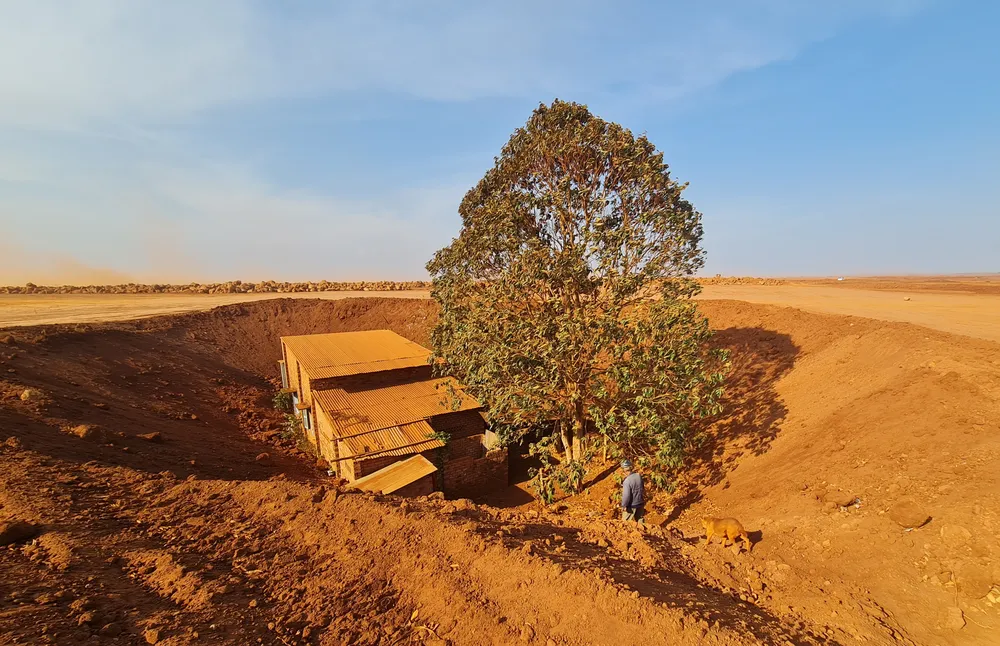 Đứng từ xa quan sát, công trường dự án sân bay Long Thành chỉ có một màu đỏ của đất. Nhìn xa rất khó để nhận biết dưới gốc cây cổ thụ là một căn nhà cấp 4, nằm lọt thỏm giữa lớp đất san lấp của dự án. Đứng từ xa quan sát, công trường dự án sân bay Long Thành chỉ có một màu đỏ của đất. Nhìn xa rất khó để nhận biết dưới gốc cây cổ thụ là một căn nhà cấp 4, nằm lọt thỏm giữa lớp đất san lấp của dự án.
