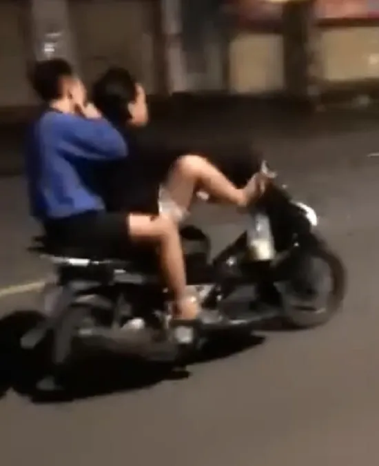 C lái xe máy bằng 2 chân chở bạn phóng nhanh trên quốc lộ. Ảnh: Cắt từ clip. lái - xe - bằng - chân.jpg