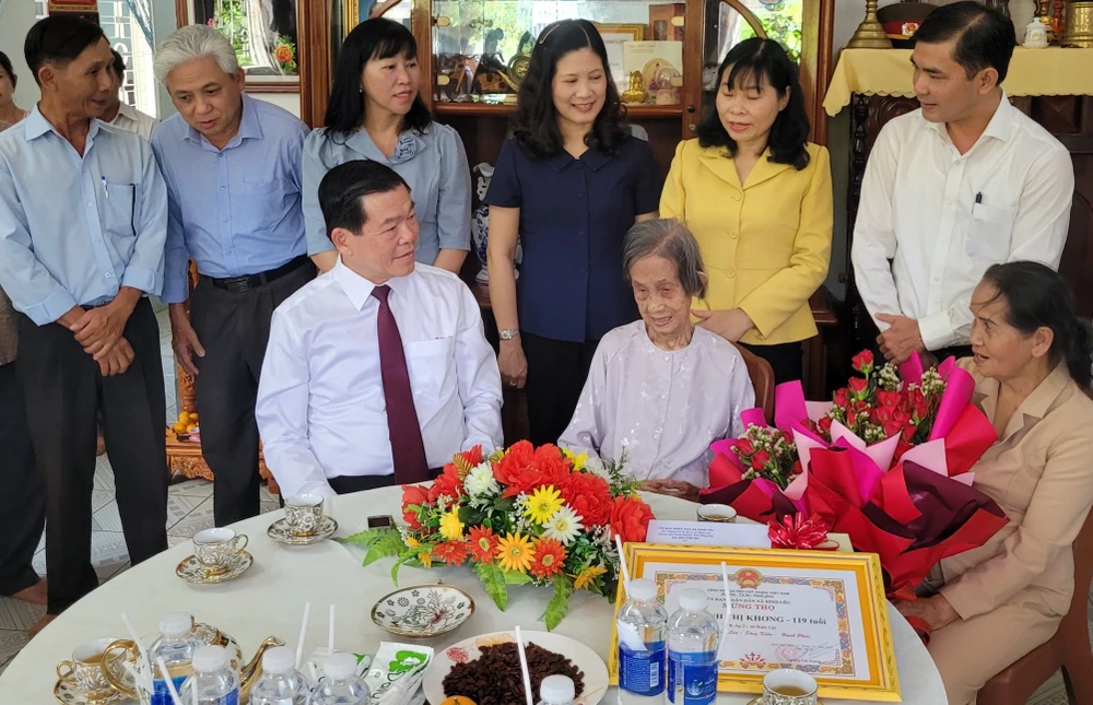 Bí thư Nguyễn Hồng Lĩnh trò chuyện với cụ bà và thành viên trong gia đình. Ảnh: VH. cụ bà.jpg