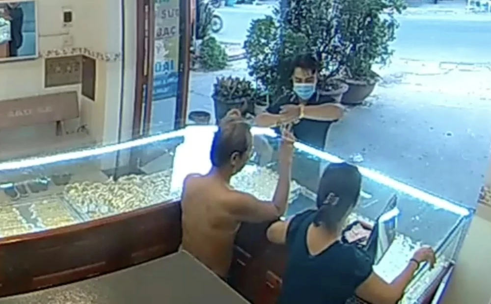 Thanh niên vào tiệm vàng vờ mua rồi cướp bỏ chạy. Ảnh: Cắt từ clip. cướp.jpg