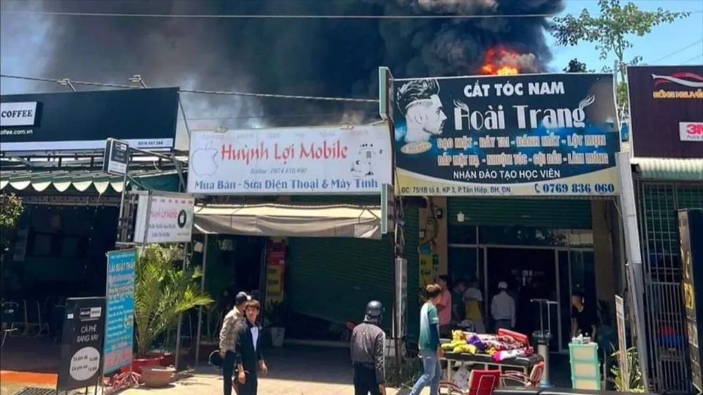 Ngọn lửa bốc cháy dữ dội phía sau hàng loạt cửa hàng khiến mọi người hoảng hốt. Ảnh: AX. Cháy .jpg
