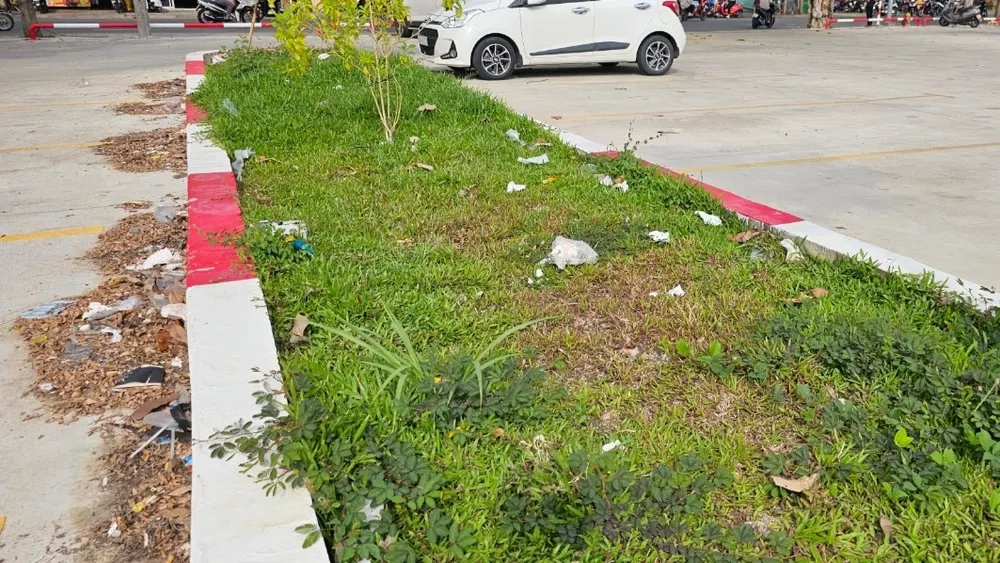 Bãi xe nhiều rác không được thu dọn gây nhếch nhác, mất vệ sinh. Ảnh: VH. bãi đậu xe 1.jpg