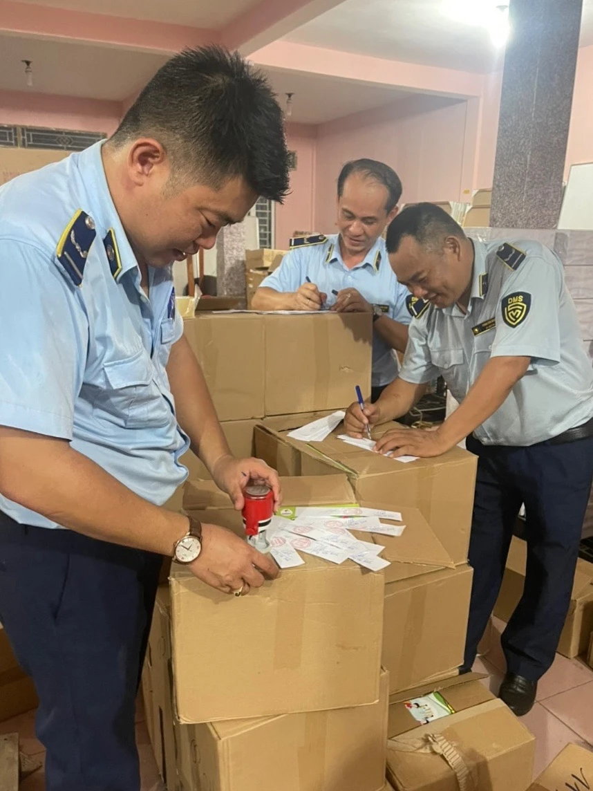 Lực lượng chức năng tiến hành niêm phong. Ảnh: QLTT. sách giáo khoa...jpg