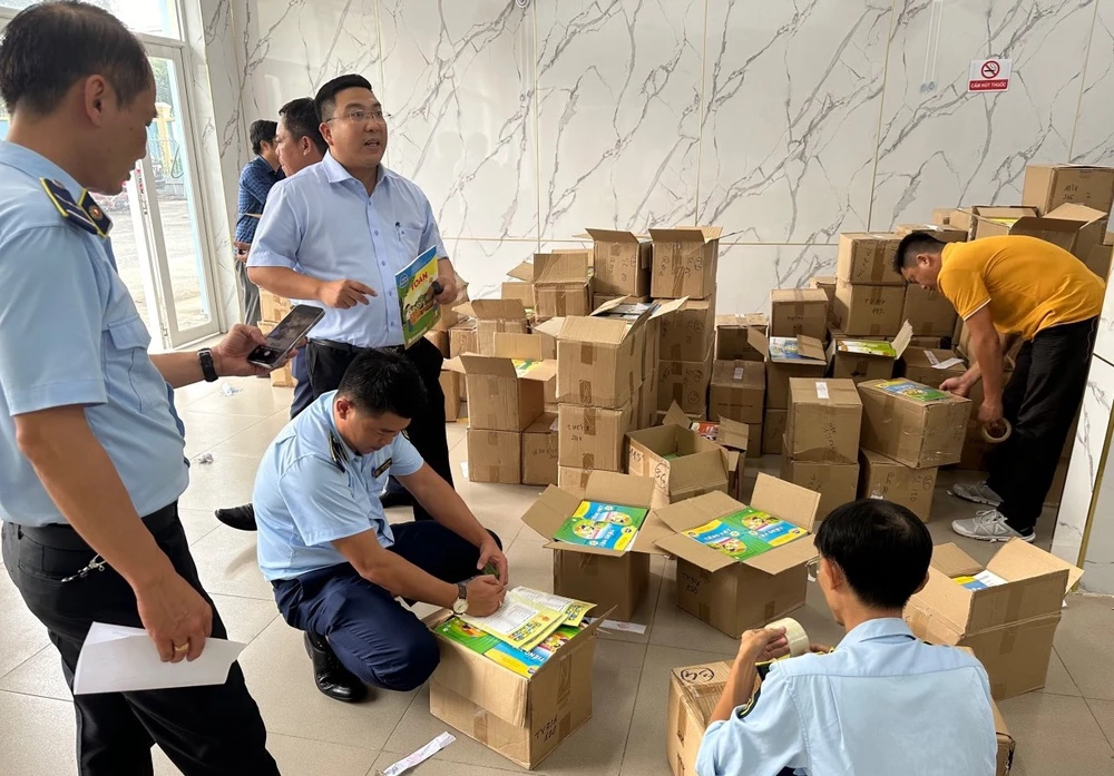 Lực lượng quản lý thị trường tiến hành kiểm tra sách giáo khoa nghi vấn có dấu hiệu giả mạo. Ảnh: QLTT. sách giáo khoa.jpg