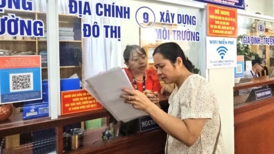 Cán bộ công chức Bộ phận một cửa của UBND phường Tân Phong, TP Biên Hoà hướng dẫn thủ tục giấy tờ cho người dân. Ảnh: VŨ HỘI. cán bộ tiêu cực.jpg