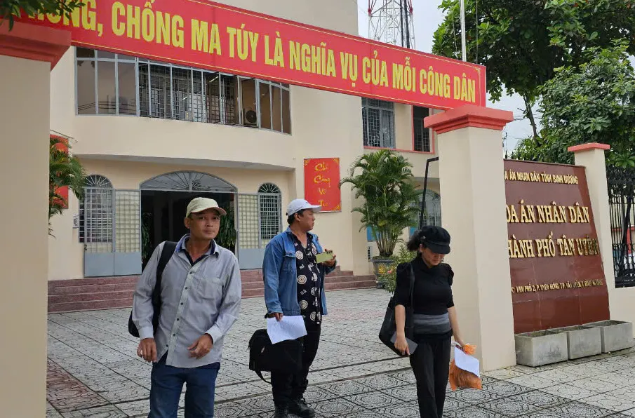 Các bị cáo trong vụ án buồn bã khi bước ra khỏi cổng TAND TP Tân Uyên khi phiên xét xử bị hoãn. Ảnh: VŨ HỘI làm phiền người khác.jpg