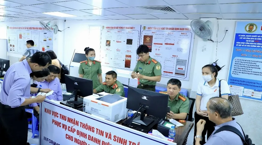 Cán bộ Phòng Quản lý Xuất nhập cảnh làm thủ tục cấp tài khoản định danh điện tử mức độ 2 cho người nước ngoài. Ảnh: CA. định danh điện tử.jpg