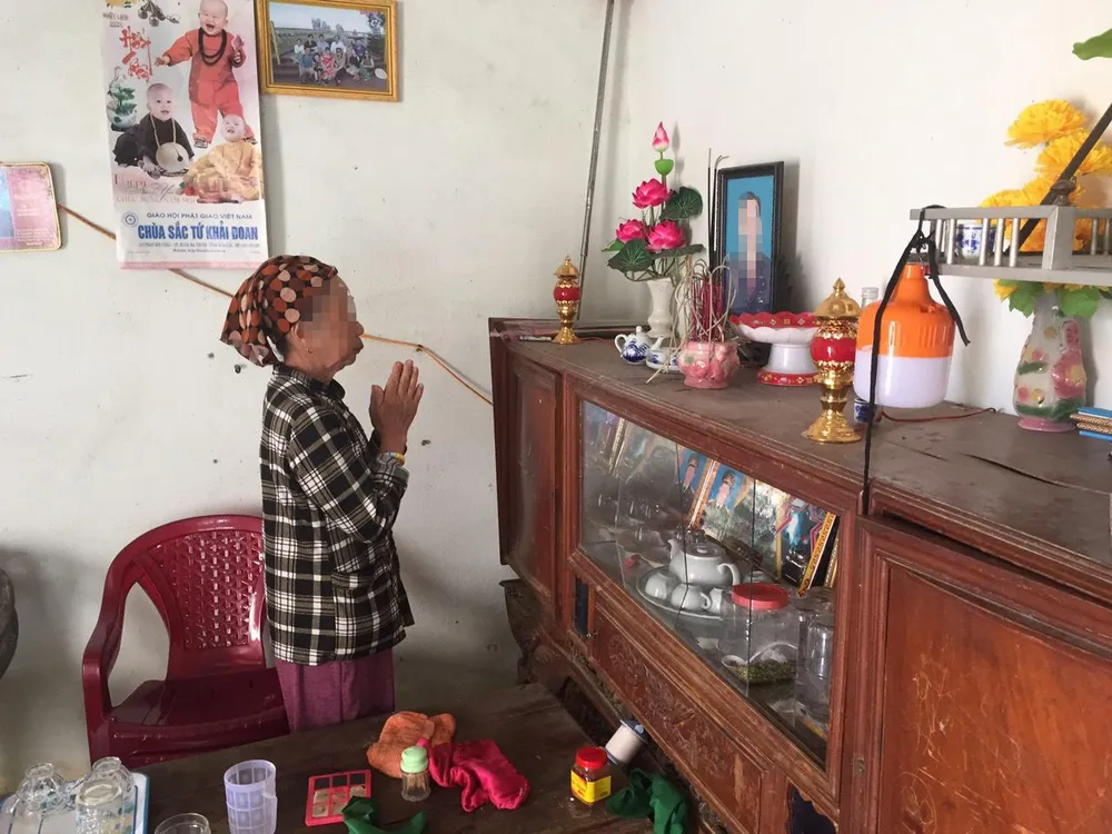 Bà Thái Thị D. thắp hương cho chồng là ông Nguyễn Đ.Ch. đã mất nhưng lại có tên trong danh sách hộ nghèo. Ảnh: VL Bà Thái Thị D. thắp hương cho chồng là ông Nguyễn Đ.Ch. đã mất nhưng lại có tên trong danh sách hộ nghèo. Ảnh: VL