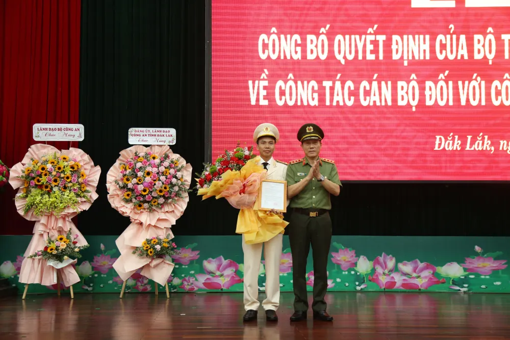 Thượng tướng Lương Tam Quang Thứ trưởng Bộ Công an trao quyết định và tặng hoa chúc mừng thượng tá Trần Quang Hiếu. Ảnh: TD