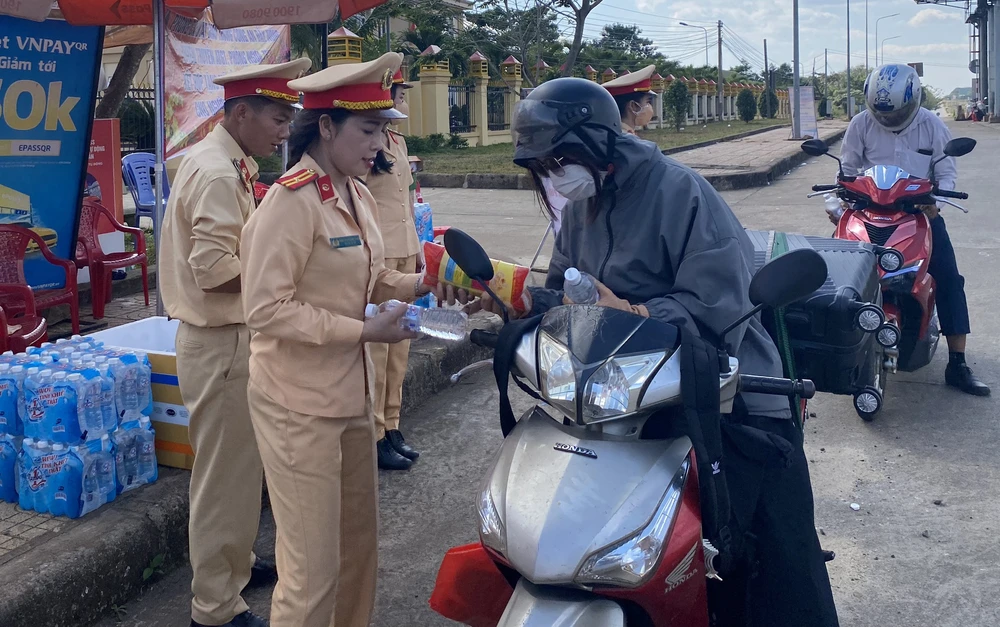 Phát nước, đồ ăn miễn phí cho người dân về Tây Nguyên ăn Tết. Ảnh: MQ