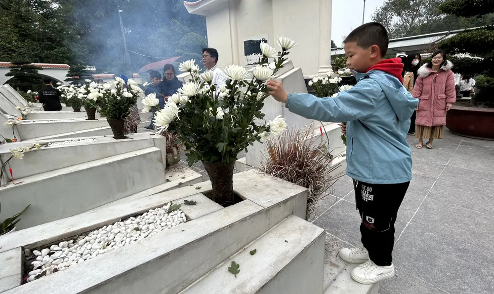 Một cháu bé thắp hương tại nghĩa trang liệt sĩ Ngã ba Đồng Lộc. Ảnh: VŨ LONG