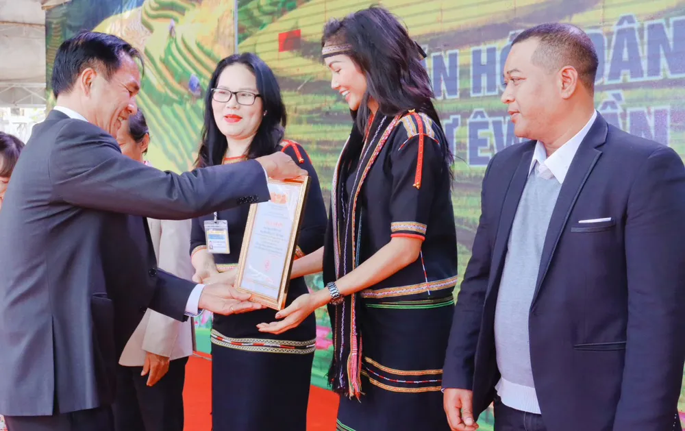 Lãnh đạo Huyện ủy Cư Kuin tặng thư cảm ơn Hoa hậu H&apos;Hen Niê. Ảnh: HC